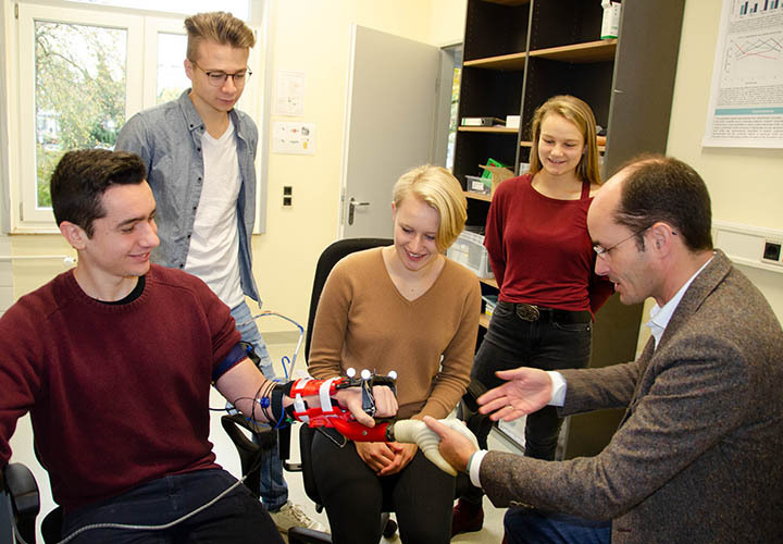 Prof. Dr. med. Arndt Schilling vom ART-Lab (rechts) stellt Studierenden des Studiengangs Mediziningenieurwesen am Gesundheitscampus Göttingen die intuitive Bedienung einer Handprothese vor.