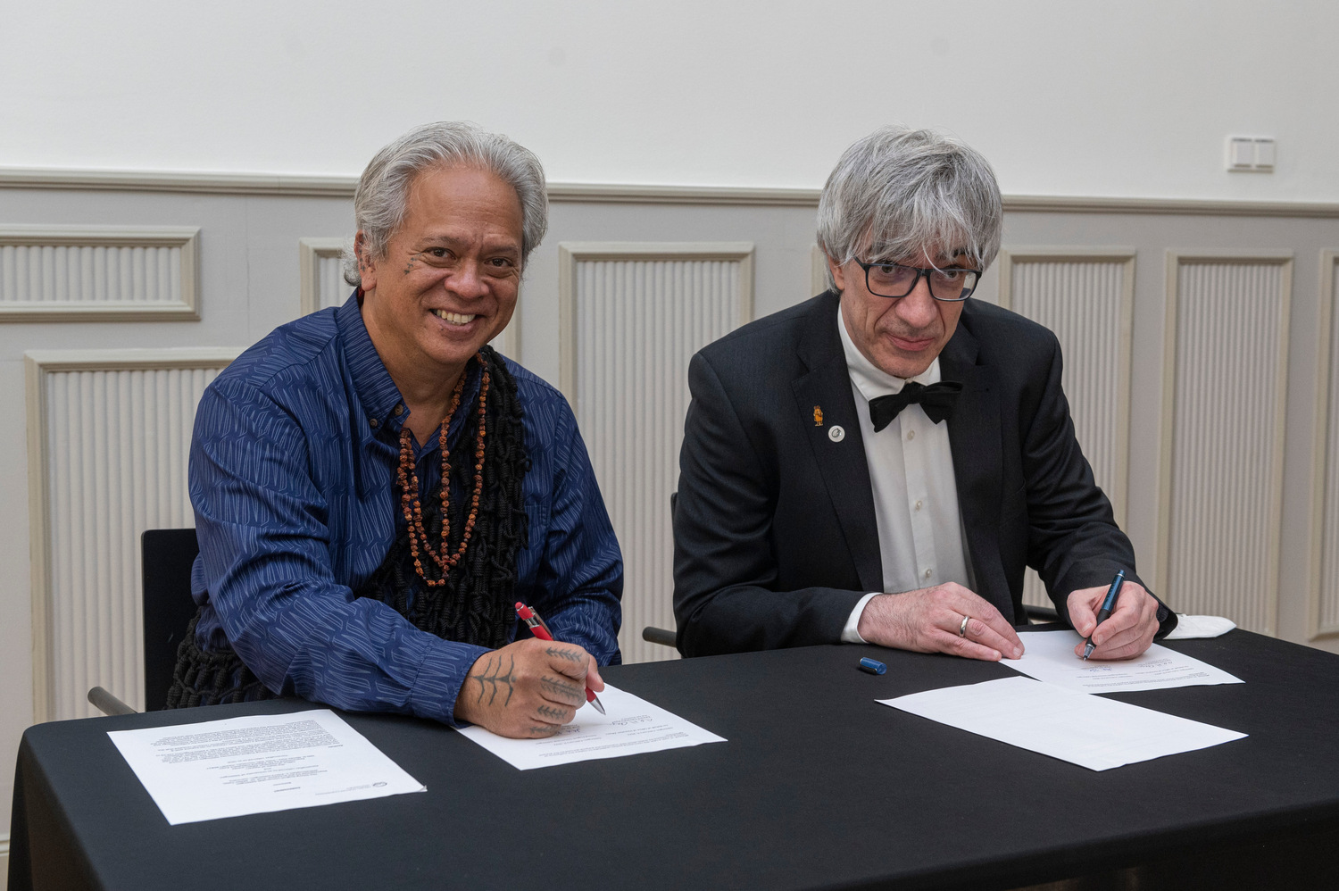 Edward Halealohu Ayau und Prof. Dr. Metin Tolan beim Unterzeichnen der Übergabevereinbarung.