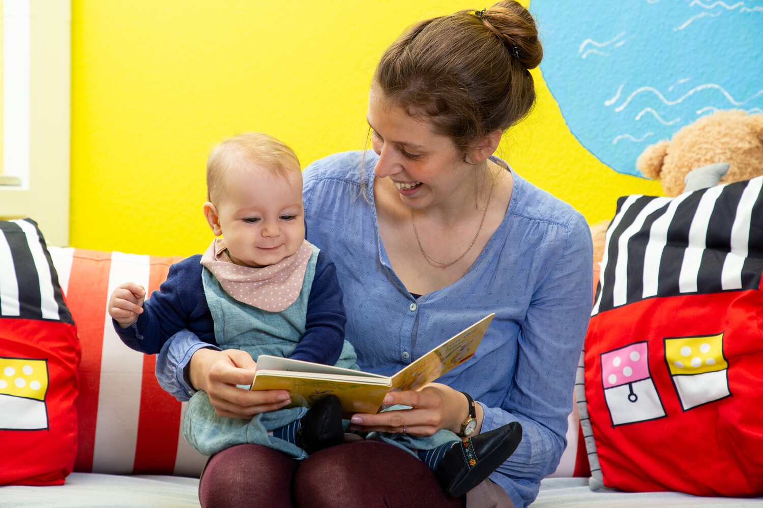 Mother and child engaged in reading a book together.
