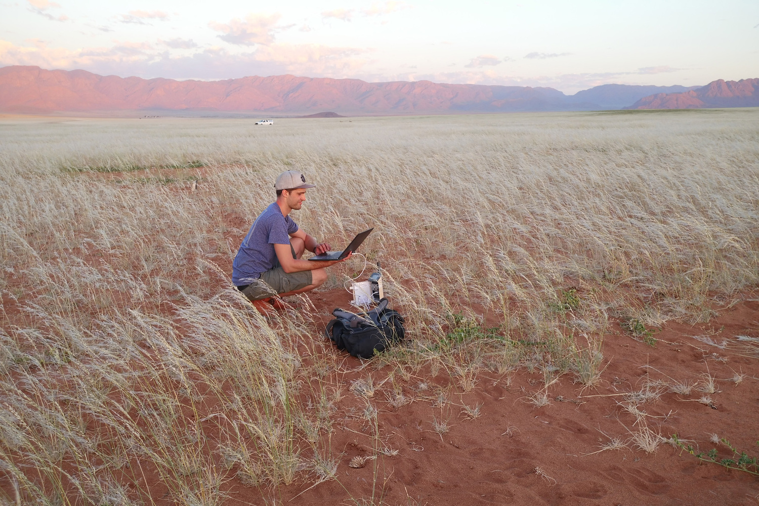 Koautor Sönke Holch beim Herunterladen der Daten von einem Datenlogger in der Namib im Februar 2021, als die Gräser ihre größte Biomasse erreichten.