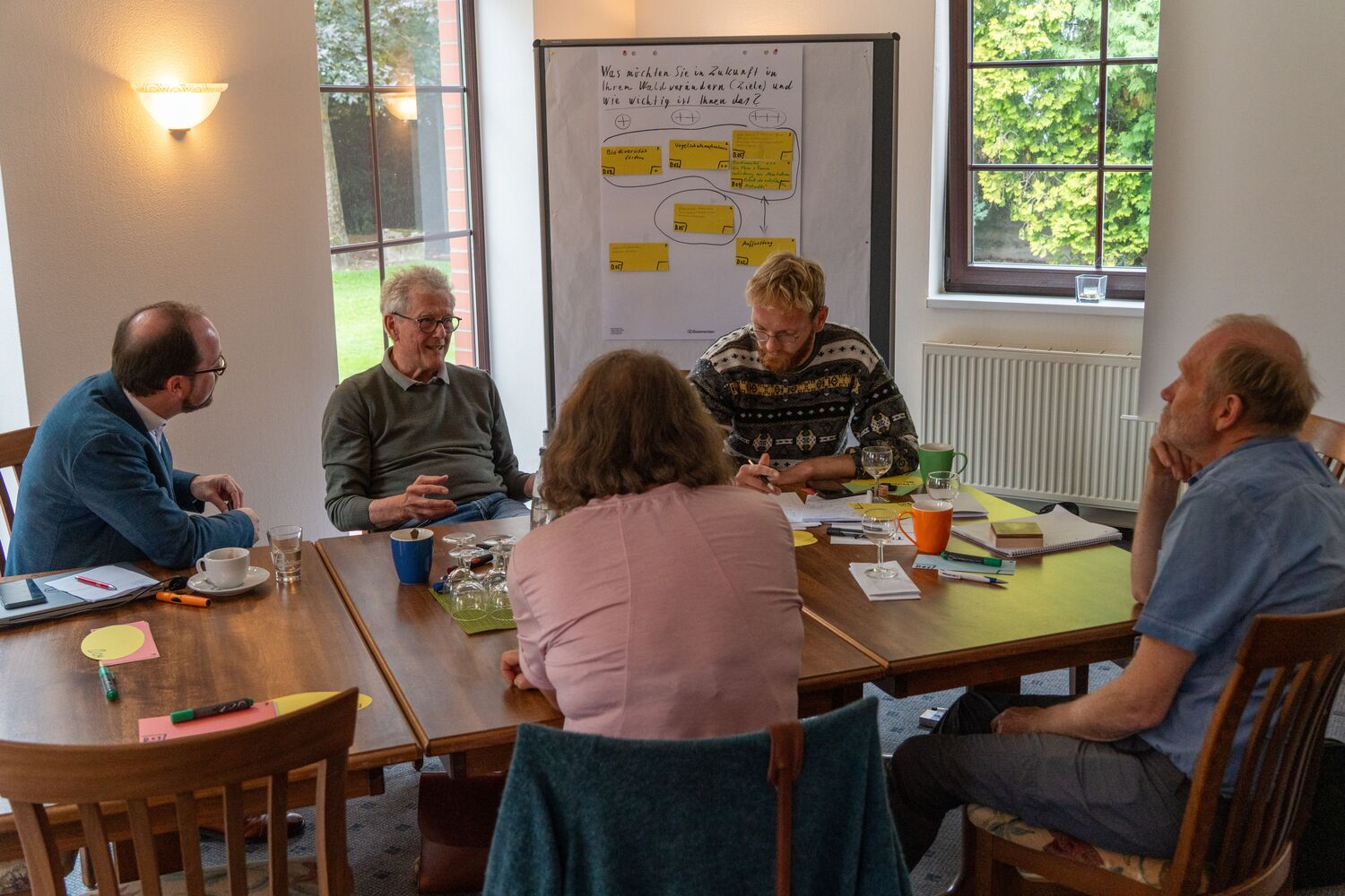 Eine Tischgruppe, die sich im Rahmen eines Lernlabors für Privatwaldbesitzende austauscht.