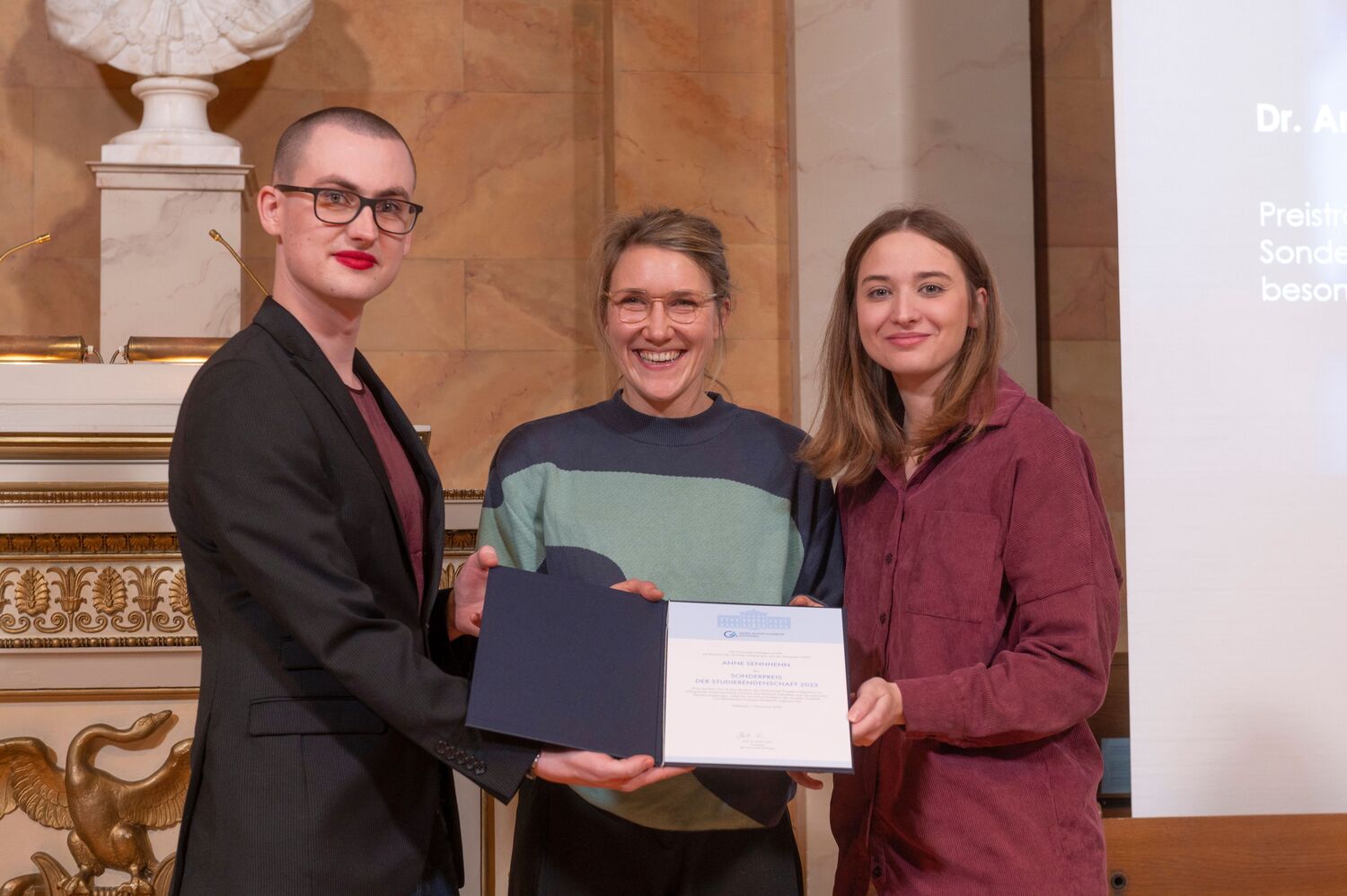 Sonderpreis der Studierendenschaft für besonderes Engagement: Preisträgerin Dr. Anne Sennhenn, links Paul Rouven Kiel, rechts Ann-Julie Blume (beide AStA).