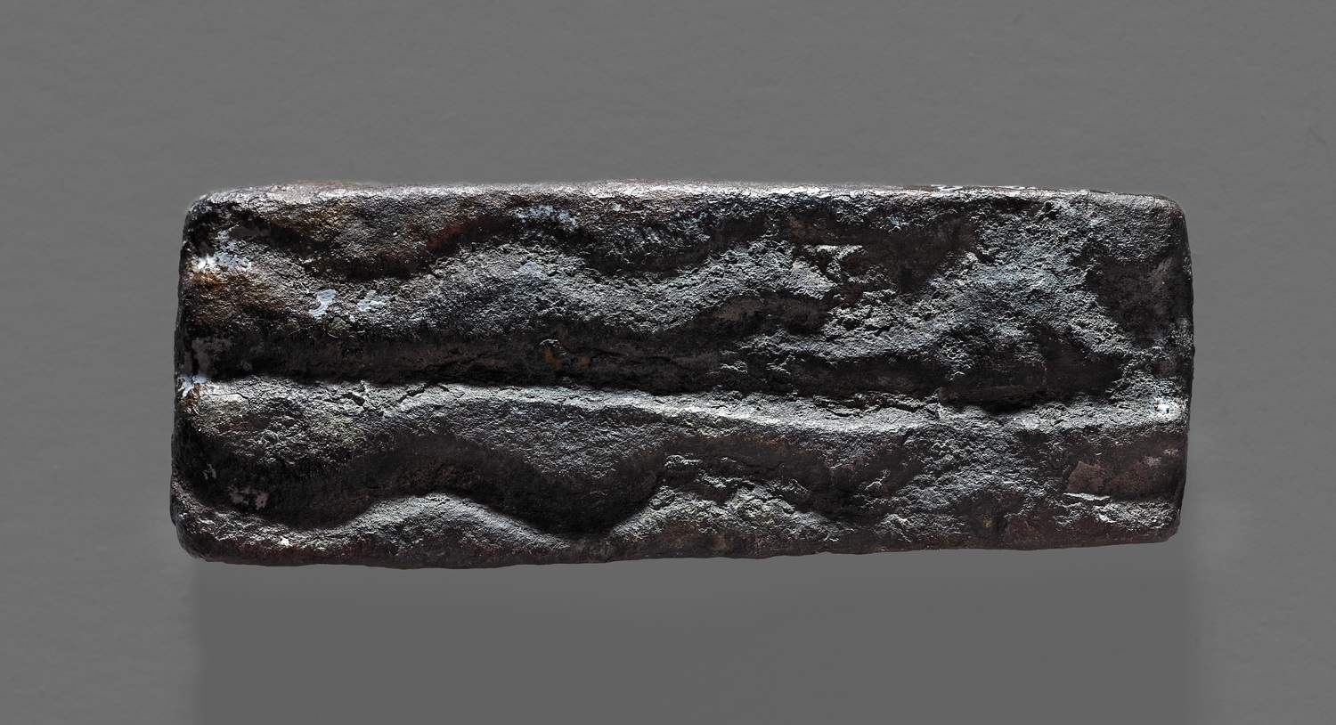 Rechtwinkliges Bronzegewicht (L. ca. 4,8 cm; 29,8 g) aus Salcombe, Devon, England.